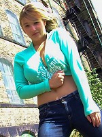 Big Boob HcupHolly posing outdoors in tight blue jeans and a green cut off top